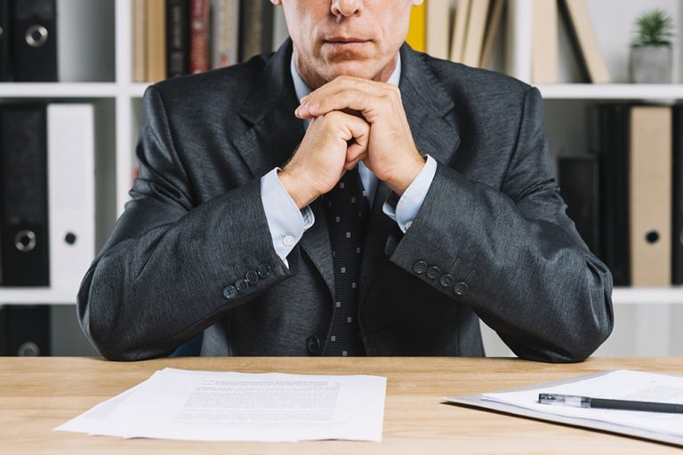 close-up-mature-businessman-with-document-paper-desk
