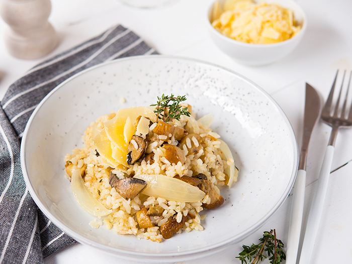 Risotto with porcini mushrooms and parmesan on a light backgroun