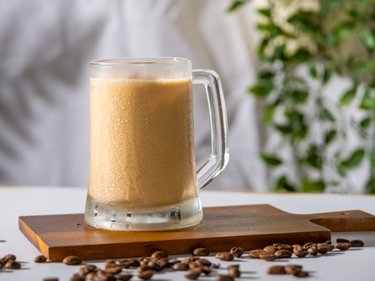 Cold coffee drink glass with ice and cream milk on old white tab