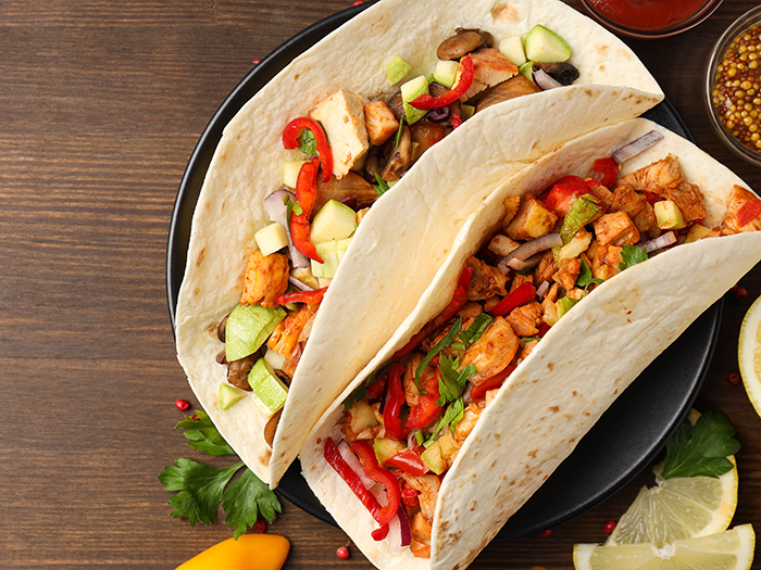 Concept of tasty food with taco on wooden background
