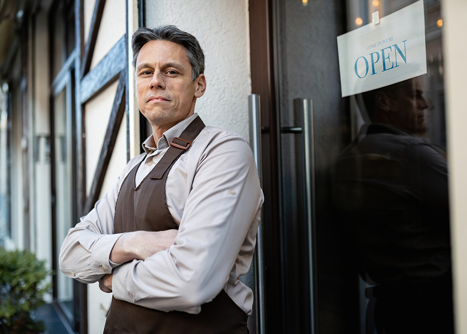 Portrait of confident pub owner at entrance door