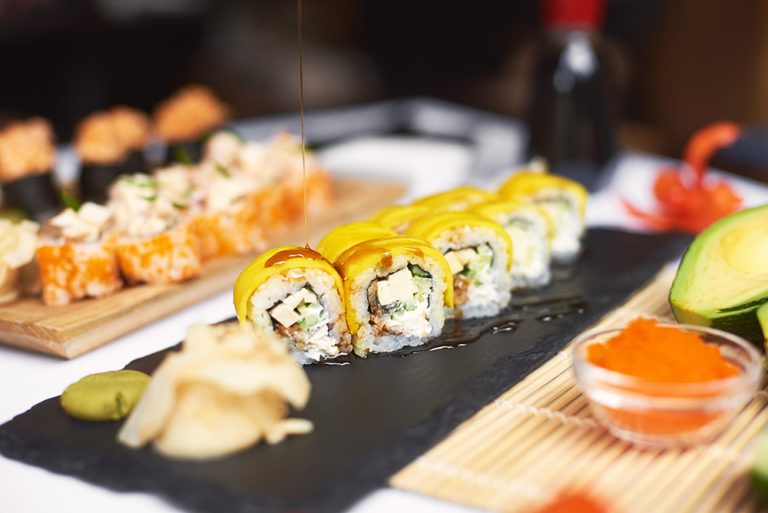 Freshly prepared sushi roll covered by teriyaki sauce