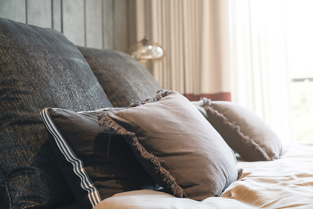 close up white beige soft pillows on bed and blanket bedroom int
