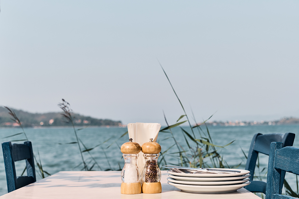 Cafe table on the background of the sea, hot afternoon. Background idea for holiday advertising or kitchen review
